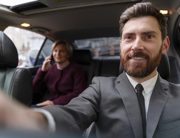 Auto con Autista Milano: conducente che interagisce con una donna in macchina