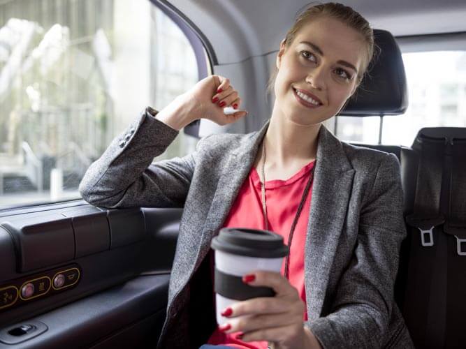 Business travel 2026: ragazza in macchina con cup di cappuccino in mano