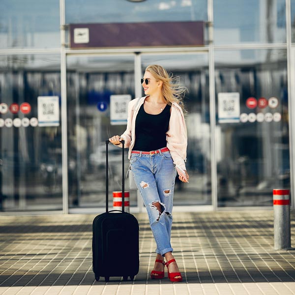 Noleggio Auto con Conducente Milano: ragazza davanti al aeroporto