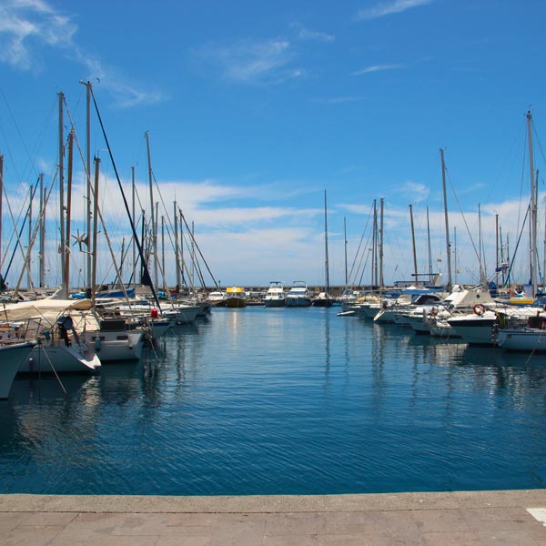 Transfer Milano e lungo raggio: barche parcheggiate nel porto di Genova sotto il cielo azzurro